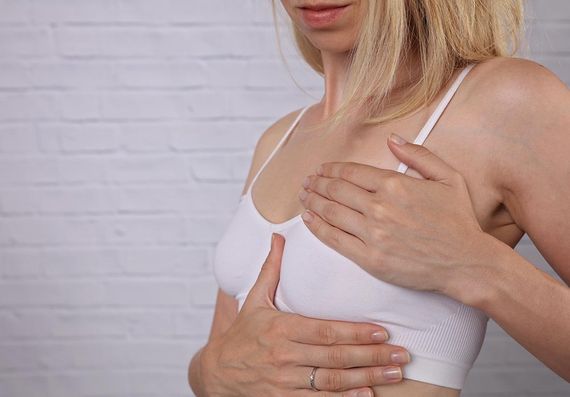 Blonde Frau tastet ihre Brust ab vor Mammographie in Tirol